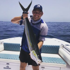 Smiling guest holding rainbow fish caught on fishing charter in Fujairah UAE