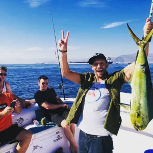 Excited guest holding dorado on fishing charter in Fujairah UAE