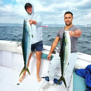Two guests each holding a rainbowfish caught during deep sea fishing charter in Fujairah UAE