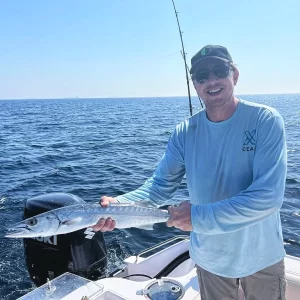 Guest holding barracuda caught on fishing charter in Fujairah UAE