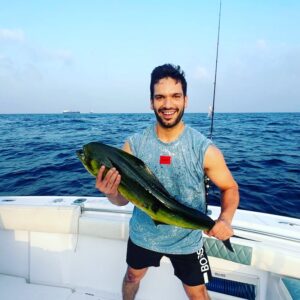 Smiling guest holding dorado on a fishing charter in Fujairah UAE