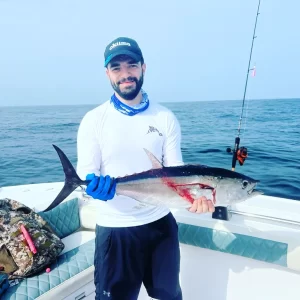 Guest holding longtail tuna on fishing charter in Fujairah UAE