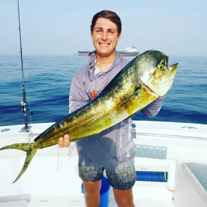 Proud guest holding dorado caught on fishing charter in Fujairah UAE