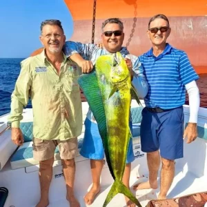 Three proud guests all showing off a dorado caught on a fishing charter in Fujairah UAE