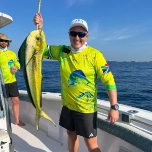 Smiling guest holding dorado caught on fishing charter in Fujairah UAE