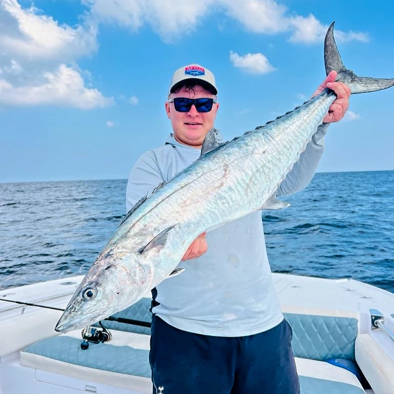 Captain Dante Vercuiel holding a freshly caught fish on a fishing charter in Fujairah UAE