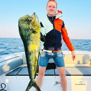 Guest holding a large dorado while on a fishing charter in Fujairah UAE