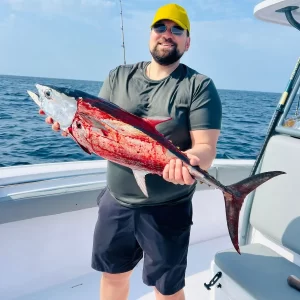 Guest holding bloody longtail tuna on fishing charter in Fujairah UAE
