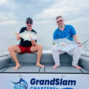 Two guests each holding a trevally caught on fishing charter in Fujairah UAE