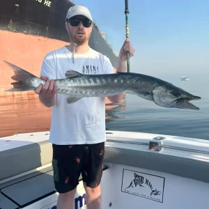 Grandslam guest holding barracuda caught during fishing charter in Fujairah UAE