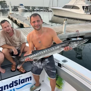 Proud guest holding barracuda caught on fishing charter in Fujairah UAE